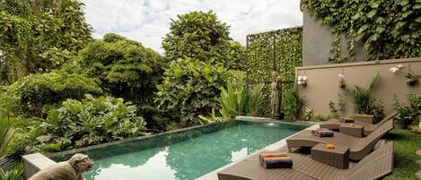 Una piscina al aire libre, tumbonas