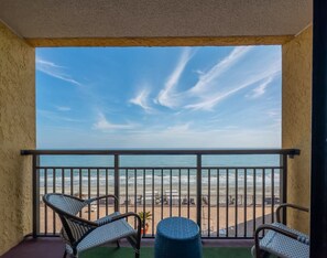 A balcony with a view of the beach, wicker chairs, and a small round table. - Caravelle 937 (Myrtle Beach)