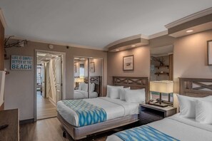 A hotel room with two beds, a desk, a chair, a mirror, and a sign on the wall. - Caravelle 937 (Myrtle Beach)