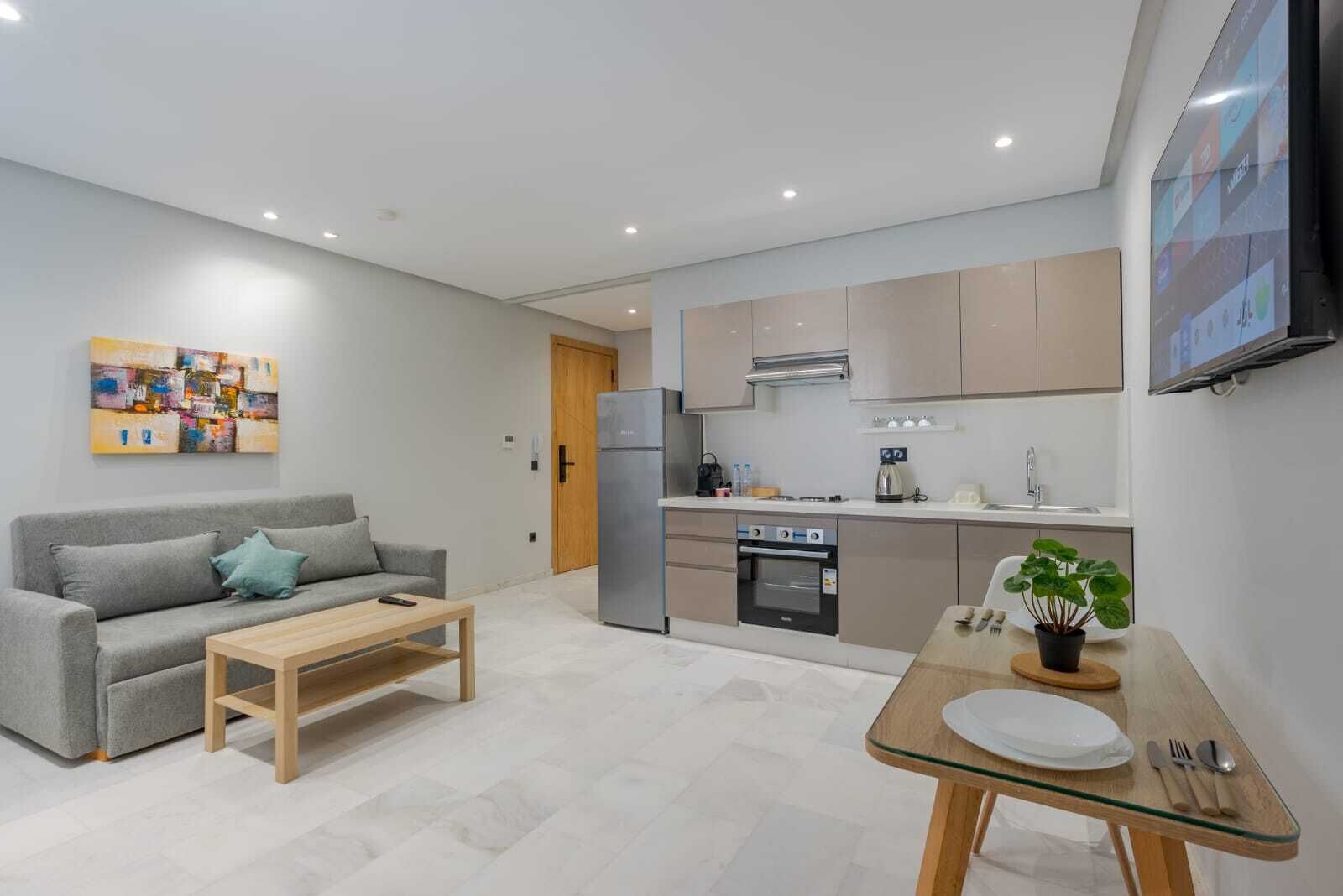A modern apartment with a living room, kitchenette, and dining area.