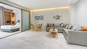 A modern living room with a sofa, a coffee table, a dining table with chairs, and a bed with a sliding door closet. - Faya Nova-central stay (Casablanca)