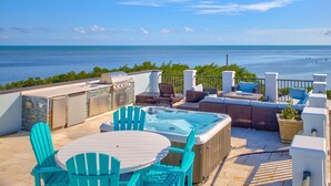 A rooftop patio with a hot tub, seating area, and a view of the ocean. - Oceanfront Rooftop Views w/ 75ft of Dockage (Marathon)