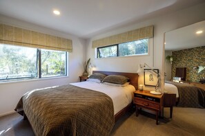 Una camera da letto con un letto grande, un comodino con una lampada, una cassettiera e uno specchio.