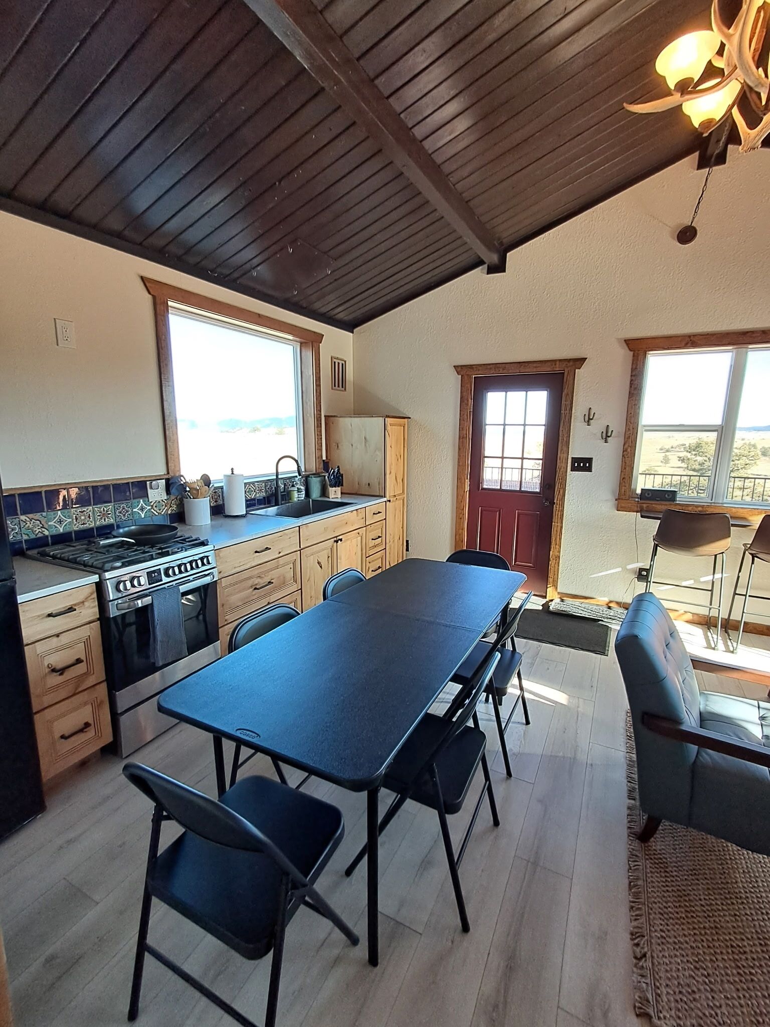 A kitchen with a large island, wooden cabinets, and a dining area with a table and chairs.
