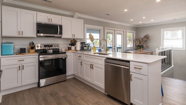 A modern kitchen with white cabinetry, stainless steel appliances, and a wooden countertop. - Soundfront Escape • Private Heated Pool • Dock • Pet Friendly (Emerald Isle)