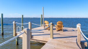 A wooden pier with a rope barrier, two wooden chairs, and a view of the water and distant horizon. - Soundfront Escape • Private Heated Pool • Dock • Pet Friendly (Emerald Isle)