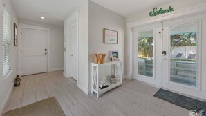 Ein sauberes, weißes Interieur mit einem Konsolentisch, der ein gerahmtes Bild und einen dekorativen Gegenstand zeigt.