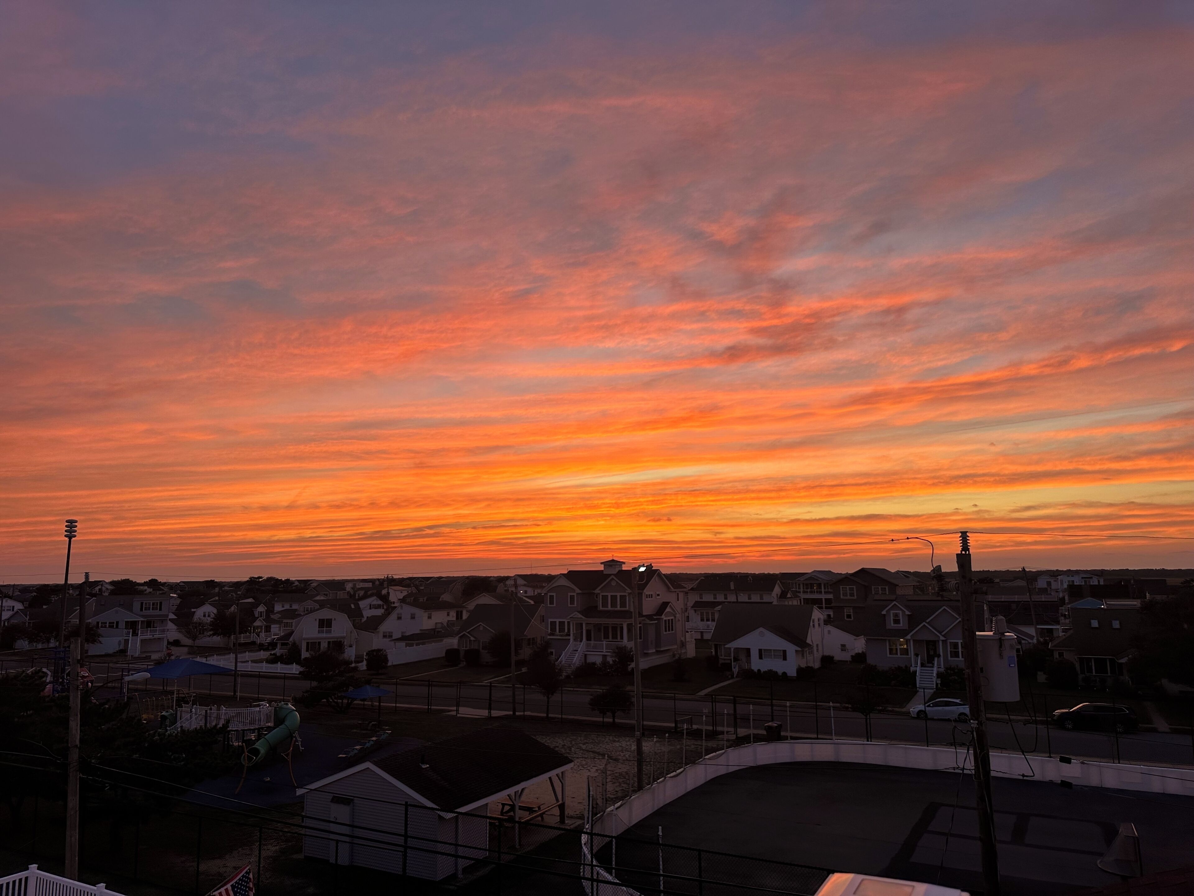 A residential area with houses and a playground during sunset.