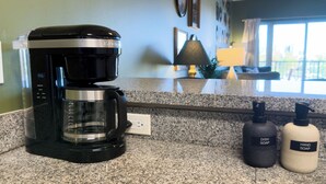 A kitchen with a coffee maker, two soap dispensers, and a granite countertop. - Retro 1 Bedroom, King Bed, Large Living Area, Parking, Gym, Close to UAB (Birmingham)
