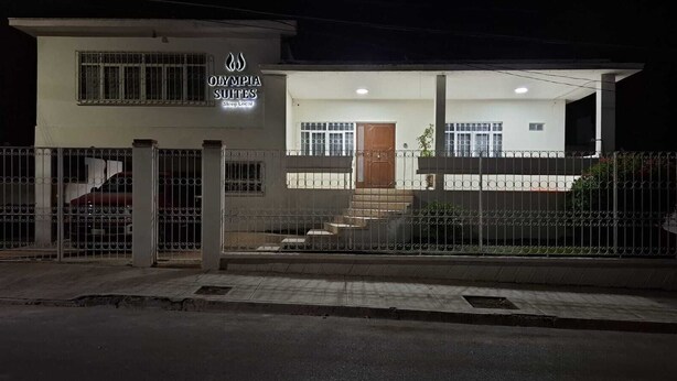 Un immeuble sur lequel on peut lire l’inscription : « Olympia Suites, soutenez les commerces locaux ».