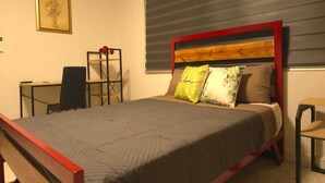 Une chambre à coucher avec un lit, un bureau et une chaise.