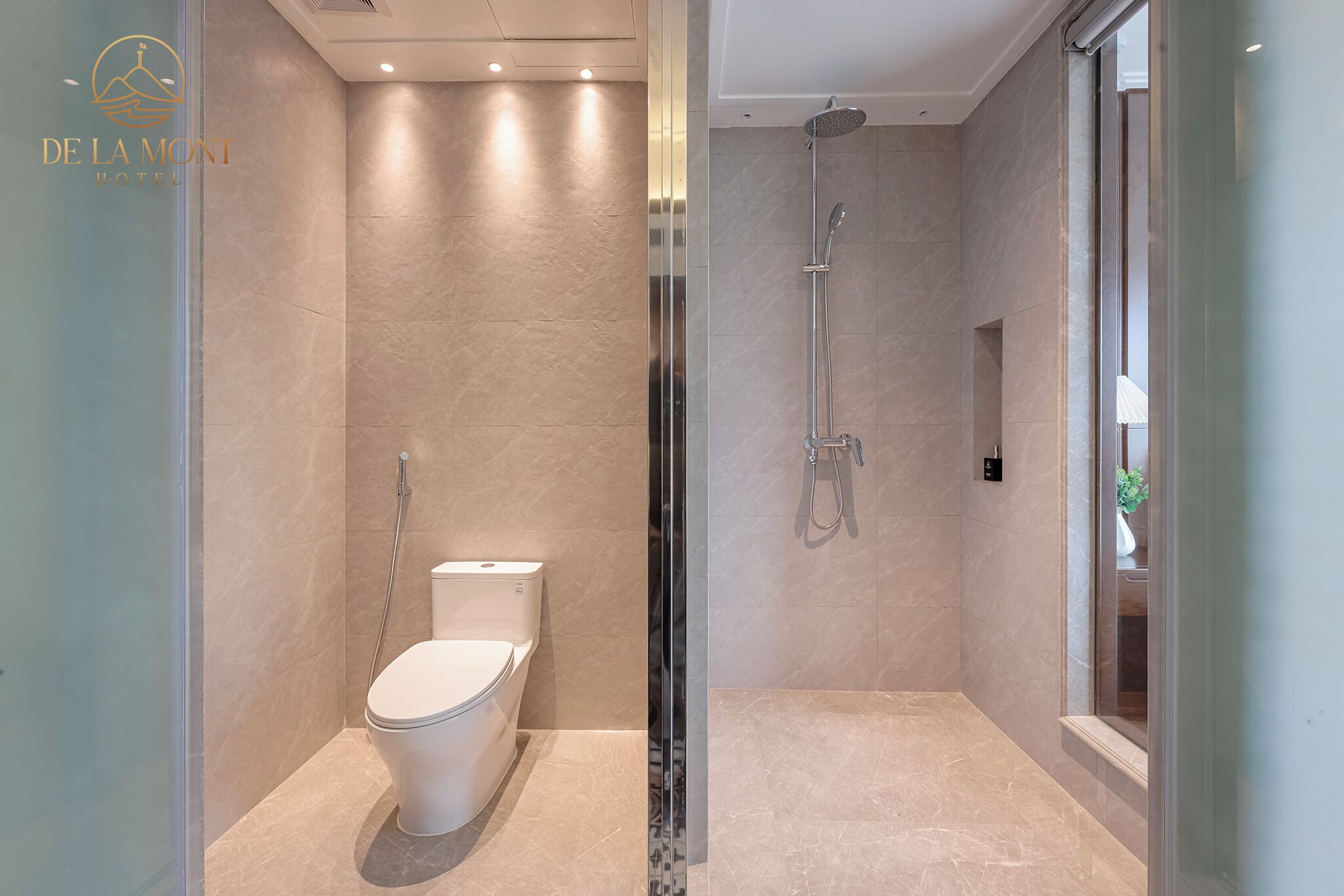 A modern bathroom with a toilet, shower, and glass door.