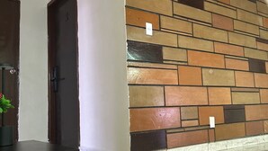 Un corridoio con parete piastrellata e una porta.