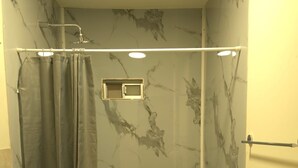 Un bagno con doccia, servizi igienici e porta asciugamani.