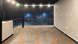 A spacious indoor area with a tiled floor, a staircase, and a textured wall. - Spring Valley Enclave (Kodaikanal)