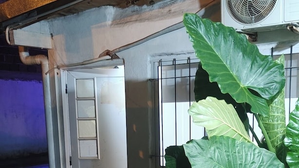 A house with a tiled entrance, a large plant, and an air conditioning unit. - Starlink apartment, furnished, 4 to 6 persons, commercial area (Puerto Iguazú)