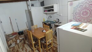A compact kitchen with a dining table and chairs, a refrigerator, and a decorative wall. - Starlink apartment, furnished, 4 to 6 persons, commercial area (Puerto Iguazú)