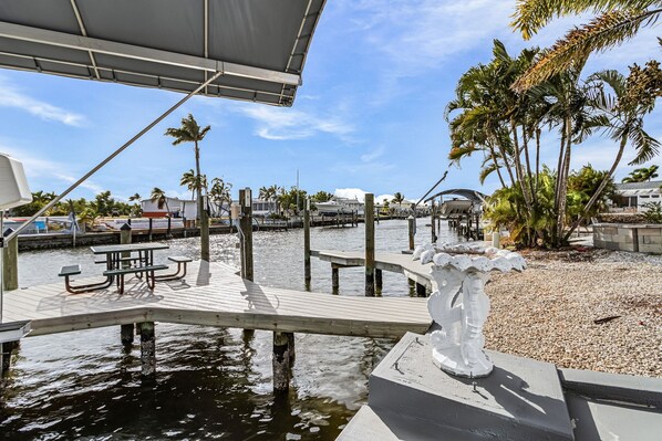 A marina with wooden docks, palm trees, and a clear sky. - Waterfront Cottage Retreat in St. James City — Brand New 1BR/1BA with Private Dock & Boat Lift (Saint James City)