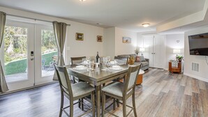 A dining area with a table set for four, a sofa, and a TV in the background.
