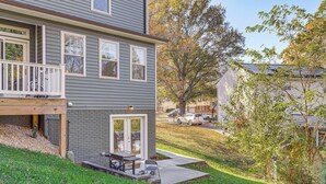 A two-story house with a porch, a small patio, and a garage.
