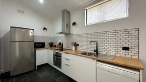 A modern kitchen with white cabinets, a stainless steel refrigerator, a microwave, a sink, and a dishwasher. - MetaWiseBnB Spacious Apartment – 6km to CBD (Petersham)