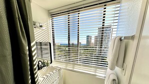 A bathroom with a window, a towel rack, and a radiator. - Cozy Ocean-view studio in the heart of Waikiki (Honolulu)