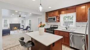 Una cocina moderna con armarios de madera, electrodomésticos de acero inoxidable y una isla central.