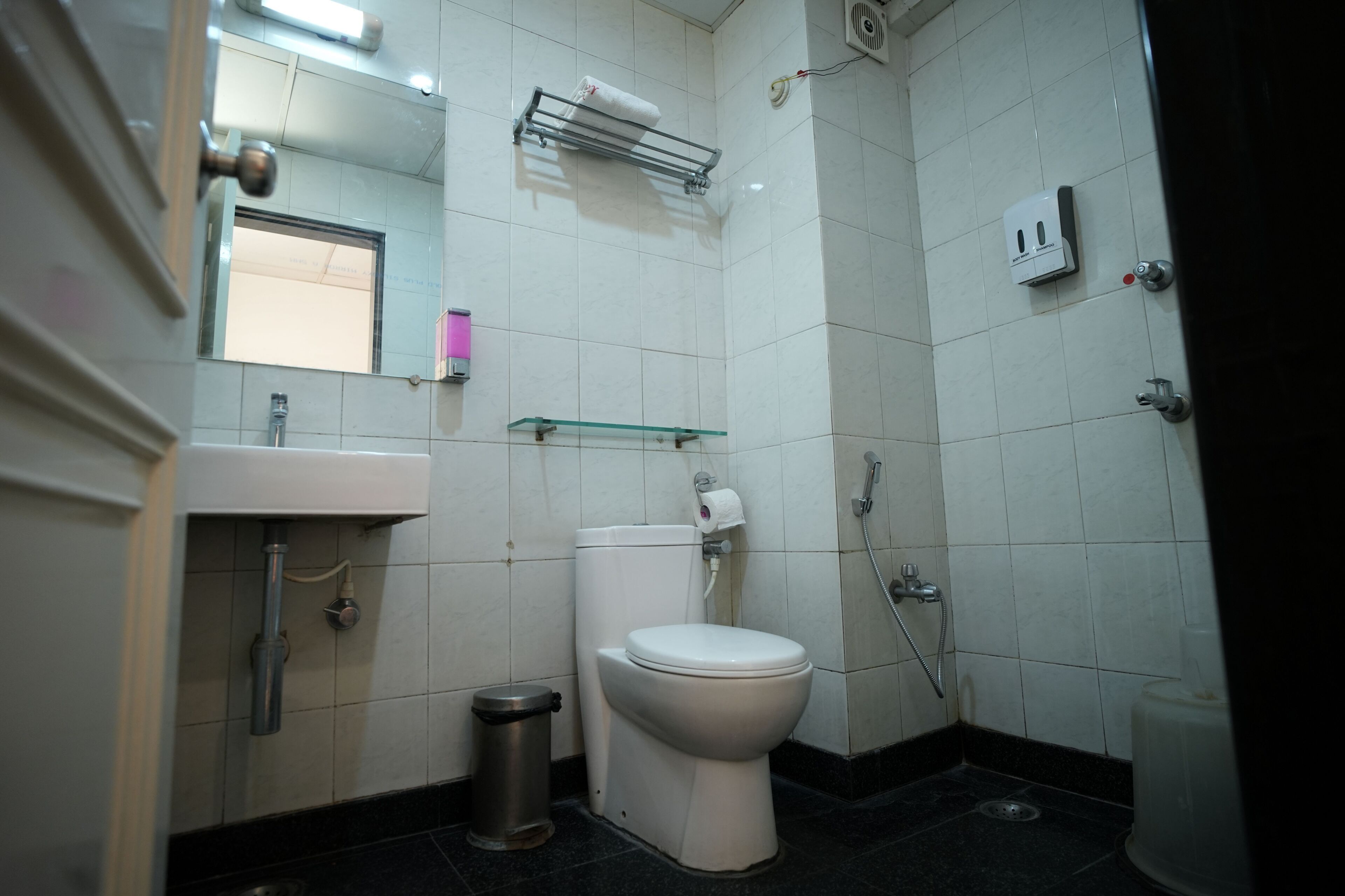 Une salle de bain équipée de toilettes, d’un lavabo et d’une douche.