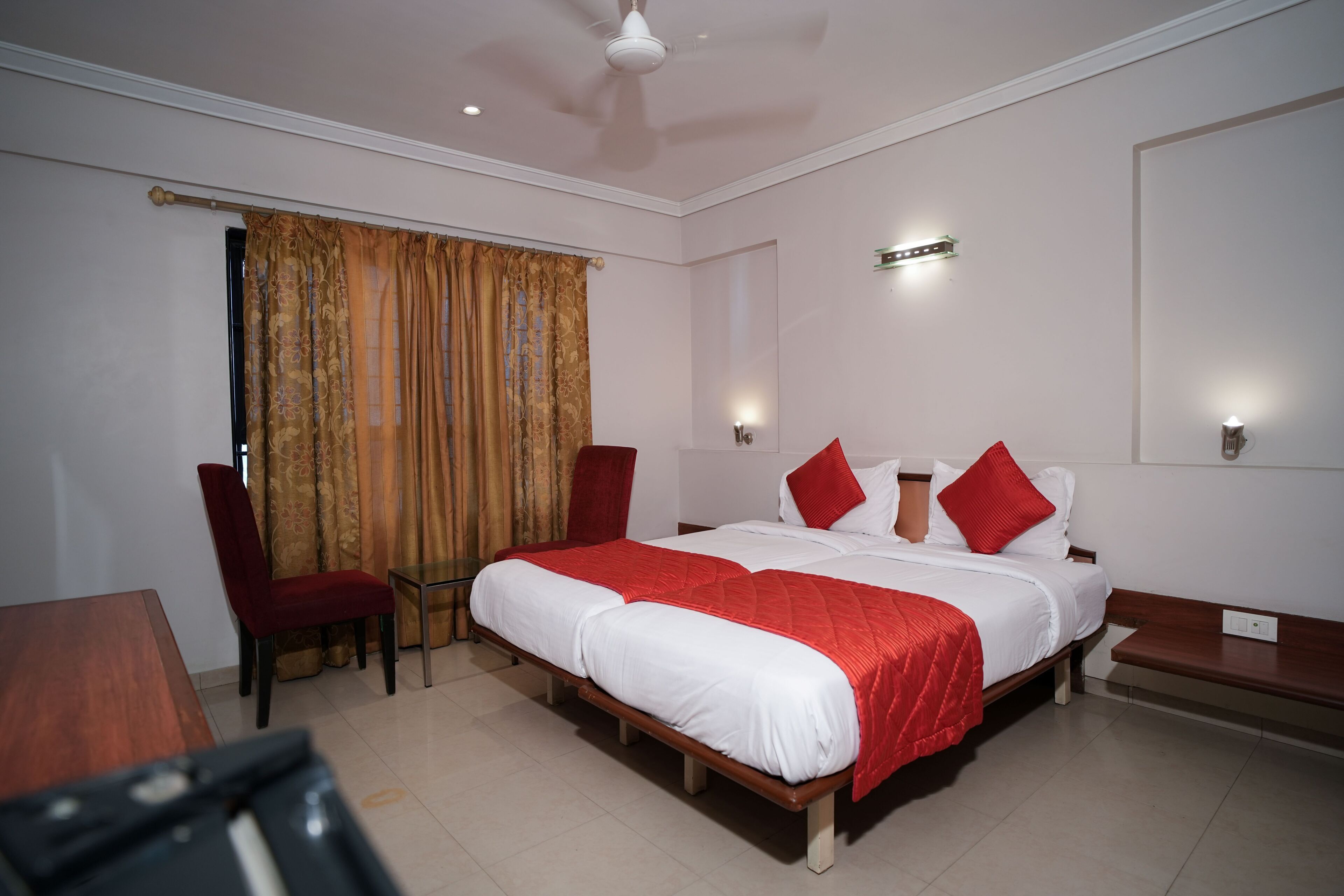 A hotel room with a large bed, a desk, and a chair.