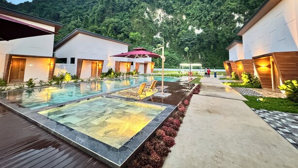 A modern hotel with a pool area, surrounded by lush greenery and a mountain backdrop. - Tambuna Retreat & Events (Ipoh)