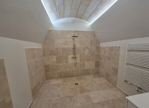 Een douche, handdoeken, zeep, toiletpapier