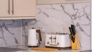 A kitchen with a white toaster, a kettle, and a knife block on the counter. - City Road by Central Serviced Apartments (Dundee)