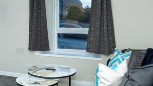 A small room with a window, a round table, and a couch. - City Road by Central Serviced Apartments (Dundee)