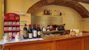 A bar area with a brick arch, wine bottles, and a Giuliano coffee display. - hotel palas (Bruzolo)