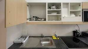Una cucina funzionale con lavandino, fornelli e scaffali aperti.