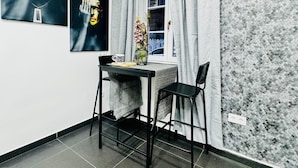 Ein Essbereich mit Tisch und Stühlen, einer Blumenvase und Kunstwerken an der Wand.