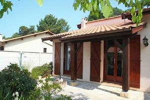 A house with a tiled roof, wooden doors, and a covered porch. - Holiday house close to the ocean G0238 (Lacanau Ocean)
