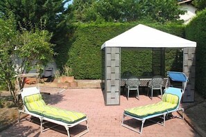 A gazebo with a table and chairs, two sun loungers, and a small table with chairs. - Holiday house close to the ocean G0238 (Lacanau Ocean)