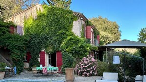 A pool area with a stone border, outdoor seating, and a pergola. - Charming house with direct view of Sainte Victoire and Picasso castle. (Vauvenargues)