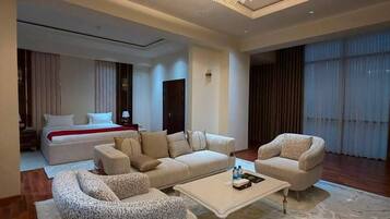 A spacious living area with a modern chandelier, a large sofa set, and a coffee table.