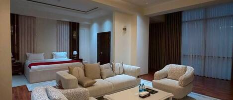 A spacious living area with a modern chandelier, a large sofa set, and a coffee table.