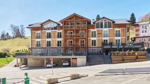 A multi-story hotel with a wooden facade, balconies, and a cafe at the ground level. - Na Kovárně by Interhome (Pec pod Snezkou)