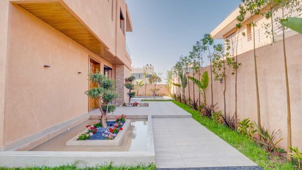 Un edificio moderno con un cortile interno, caratterizzato da una fontana centrale e diverse piante.