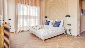 Un'ampia camera da letto con un letto grande, una cassettiera in legno e un pannello decorativo a parete.