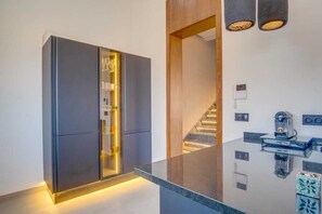 A modern kitchen with a built-in refrigerator, a glass cabinet, and a coffee machine. - Villa joud (Marrakech)