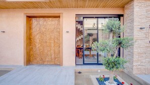 Un edificio moderno con una porta in legno e un ingresso in vetro.