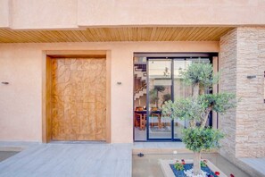 A modern building with a wooden door and a glass entrance. - Villa joud (Marrakech)