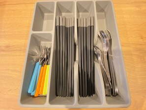Ein Ordnungssystem mit Fächern für Besteck und Küchenutensilien.