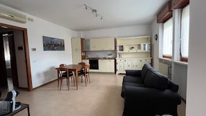Un espacio habitable compacto con comedor, kitchenette y sofá.