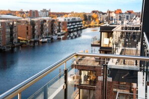 A view from a high-rise building overlooking a river with buildings and a bridge in the background. - Loft Fluxus Emden | Delft View (Emden)